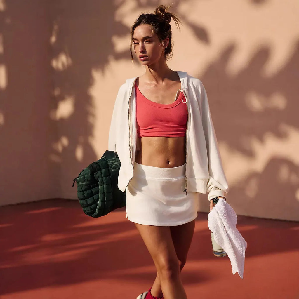 A woman's grey street-style hooded jacket and matching miniskirt outfit on a hanger.