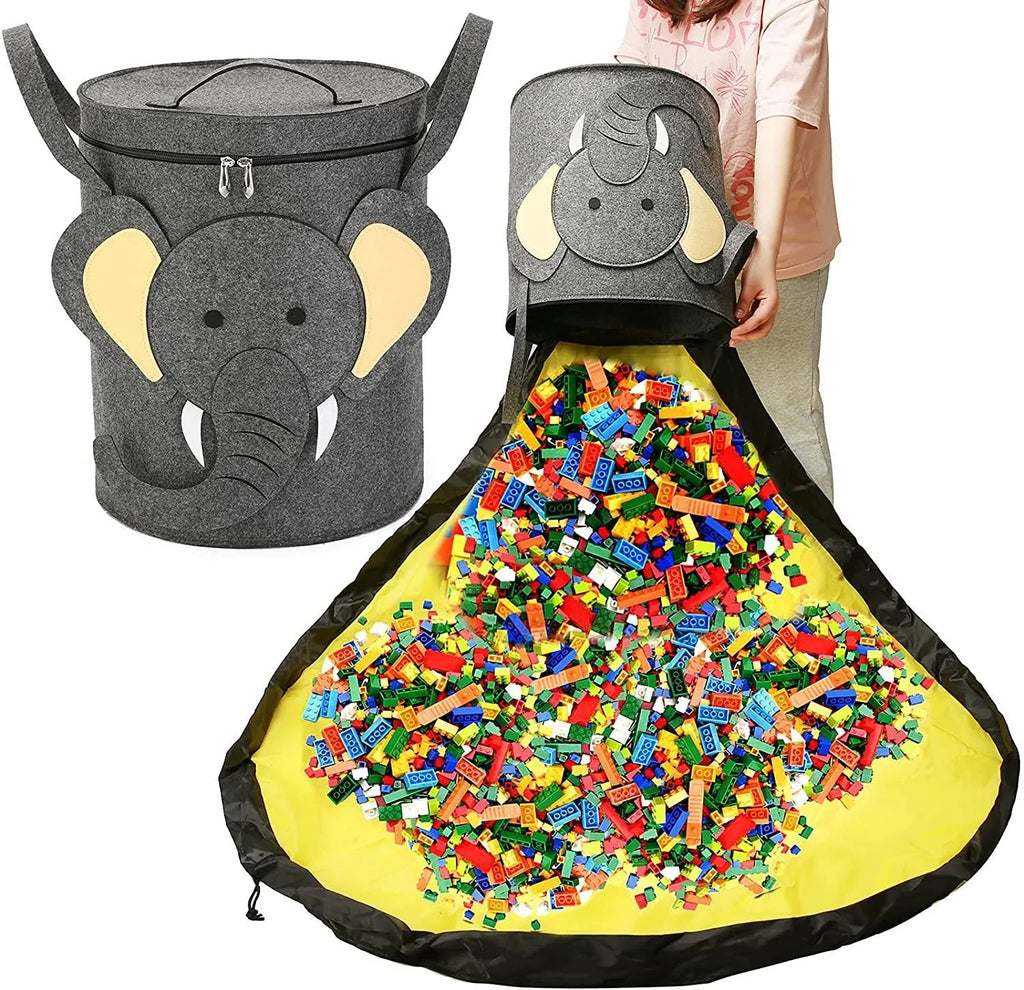Green felt cube-shaped toy storage bag opened flat as a play mat next to toys, showing pull rope.