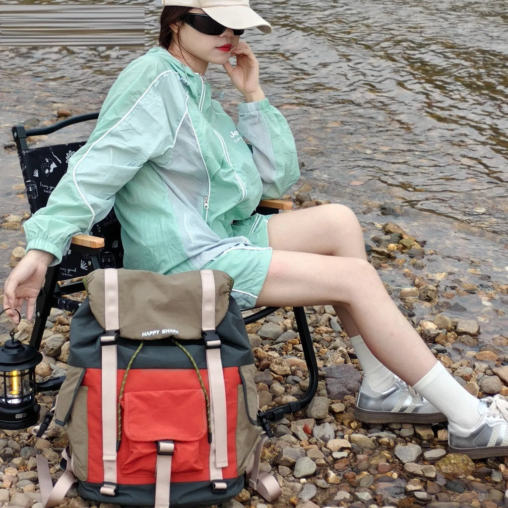 Orange and green outdoor backpack with multiple compartments and air pillow belt system