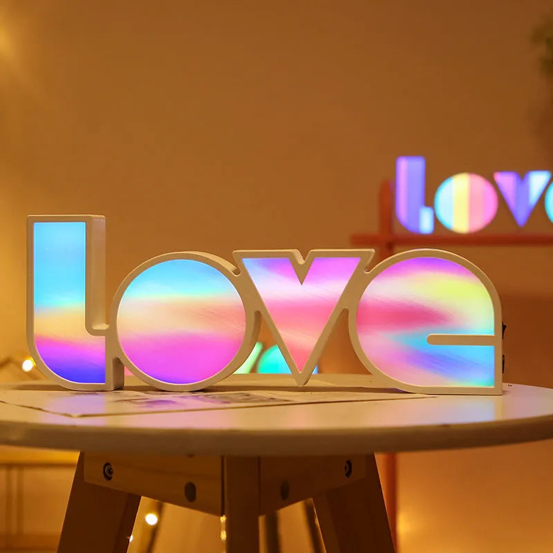 LED Love light with rainbow 'LOVE' lampshade on a table.