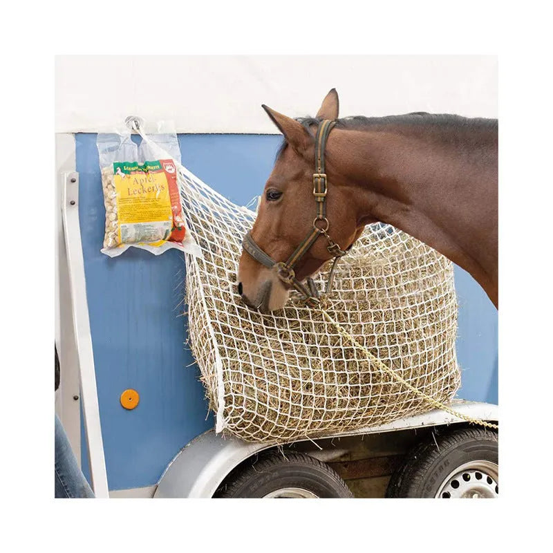 Woven grid horse feeding bag in black hanging, suitable for cattle and sheep.