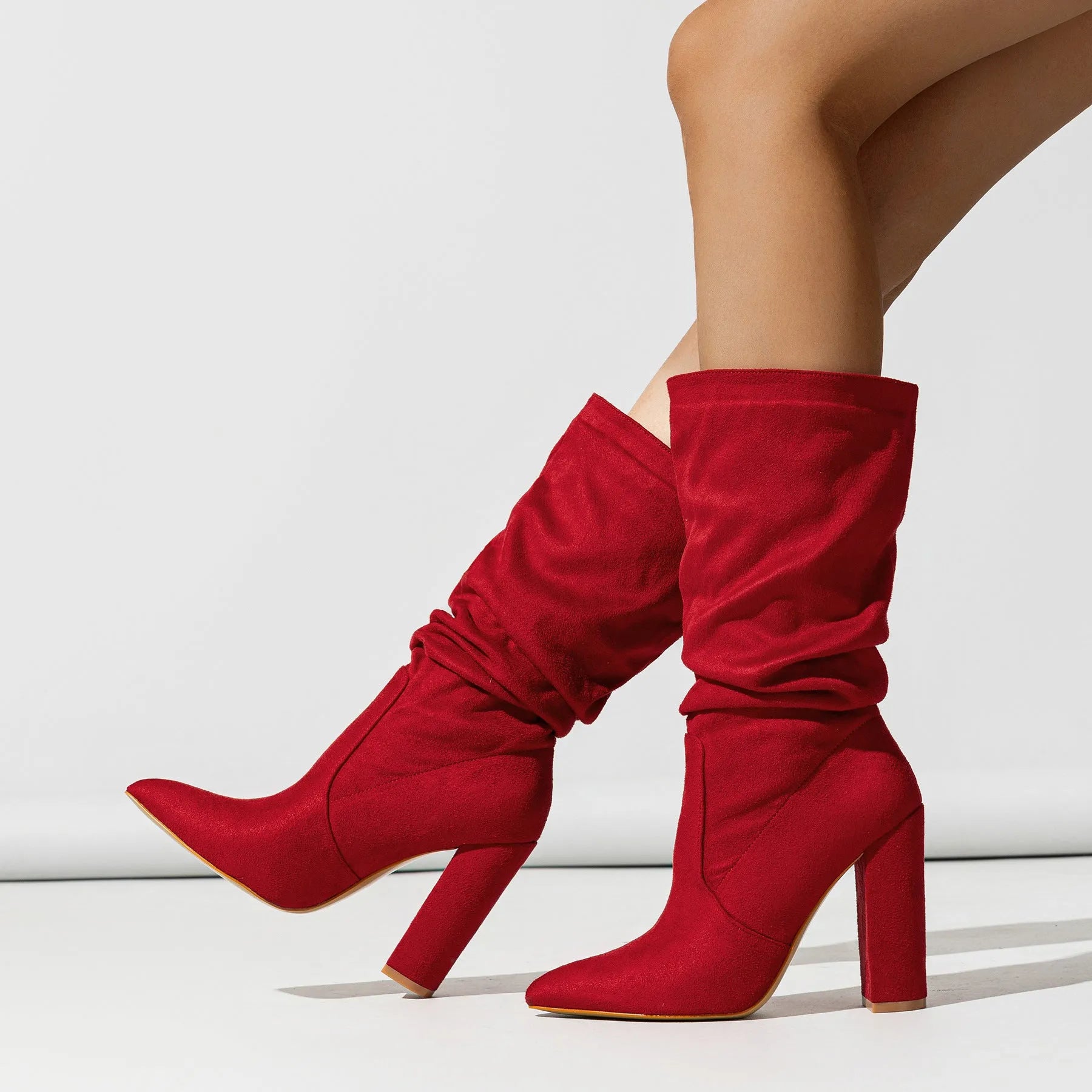 Women's black suede chunky high heel boots with pointed toe and mid-calf length.
