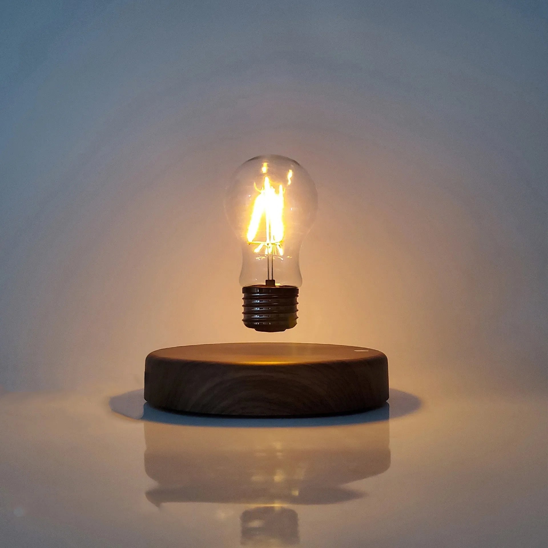 Magnetic levitation bulb night light in solid wood colour with UK plug on a desk.