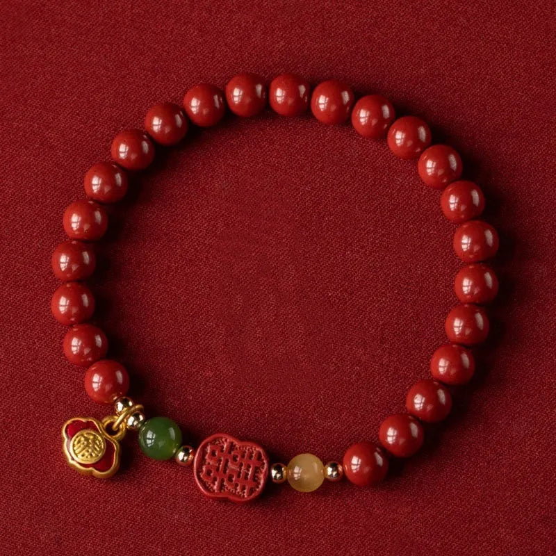 Close-up of a cinnabar Happy Eyebrow bracelet with Emperor Sandstone beads and a carved Fu character.
