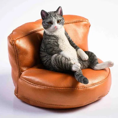 Lazy cat and sofa miniature car dashboard ornament made from resin, approximately 7.5cm high.