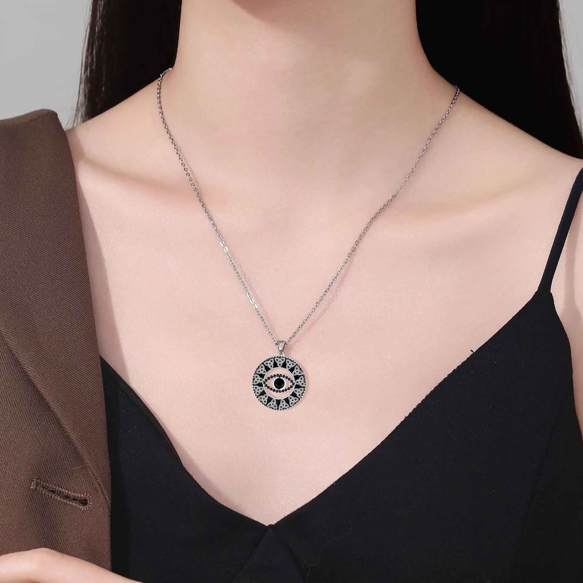 Close-up of a women's copper Devil's Eye pendant necklace on a cross chain, with a light luxury electroplated finish.
