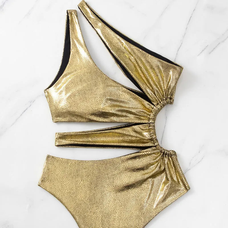 Women's gold backless one-piece swimsuit on a mannequin, showing sleeveless design.