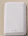 A black magnetic wireless power bank attached to the back of a mobile phone.