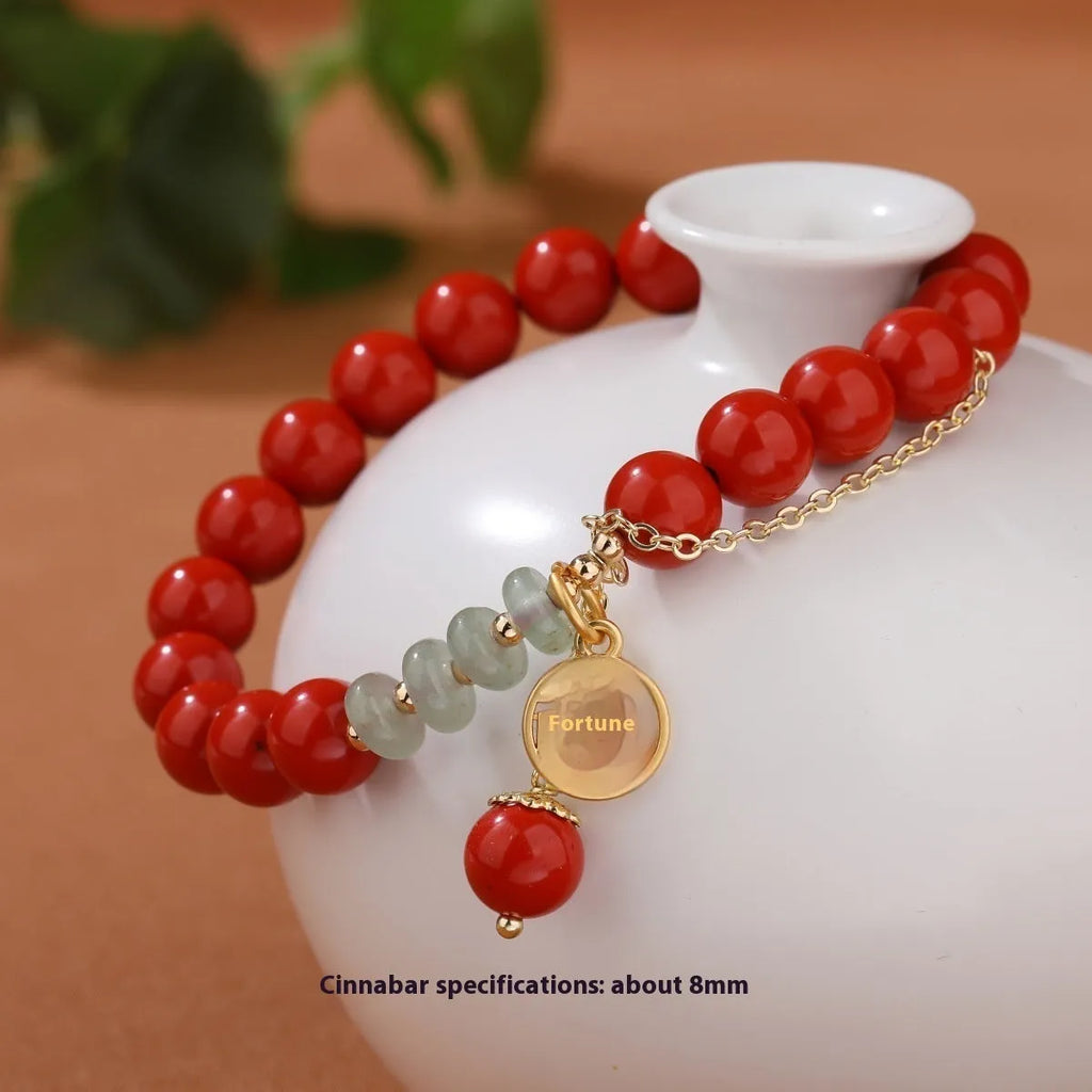 Handcrafted red sand cinnabar bracelet with fu character charm, jade spacer beads, and tassel decoration