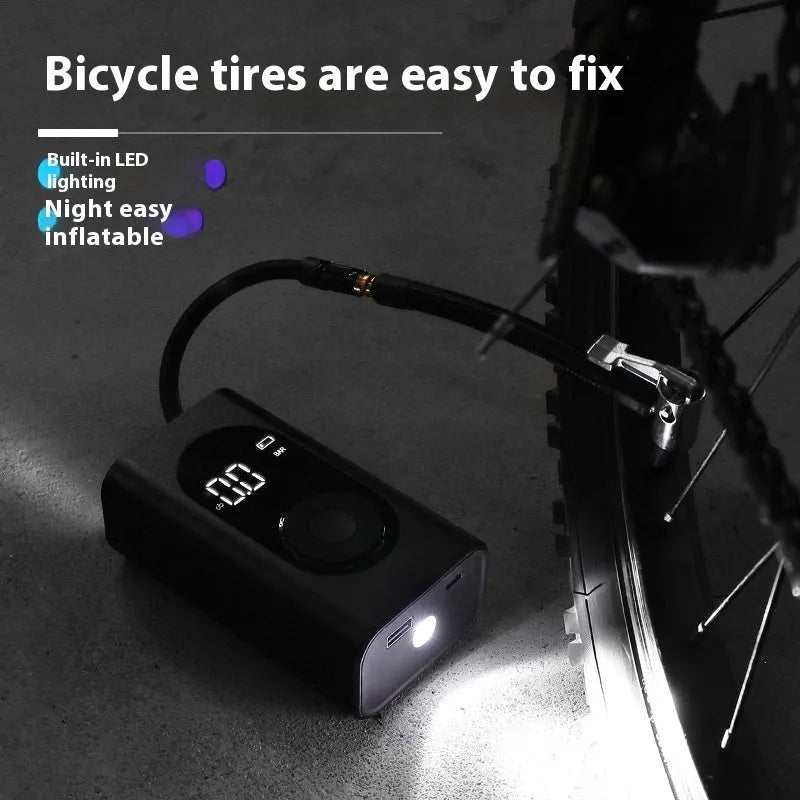 Compact black handheld wireless tyre inflator with digital display, attached air hose, and USB cable.