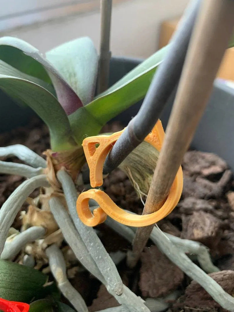 Colourful cat-shaped plastic plant clip for stem support in gardening.