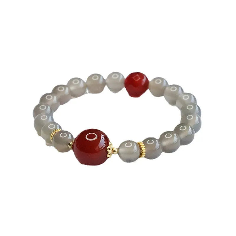 Smoky purple and red agate bracelet with 8mm geometric beads on a wrist.