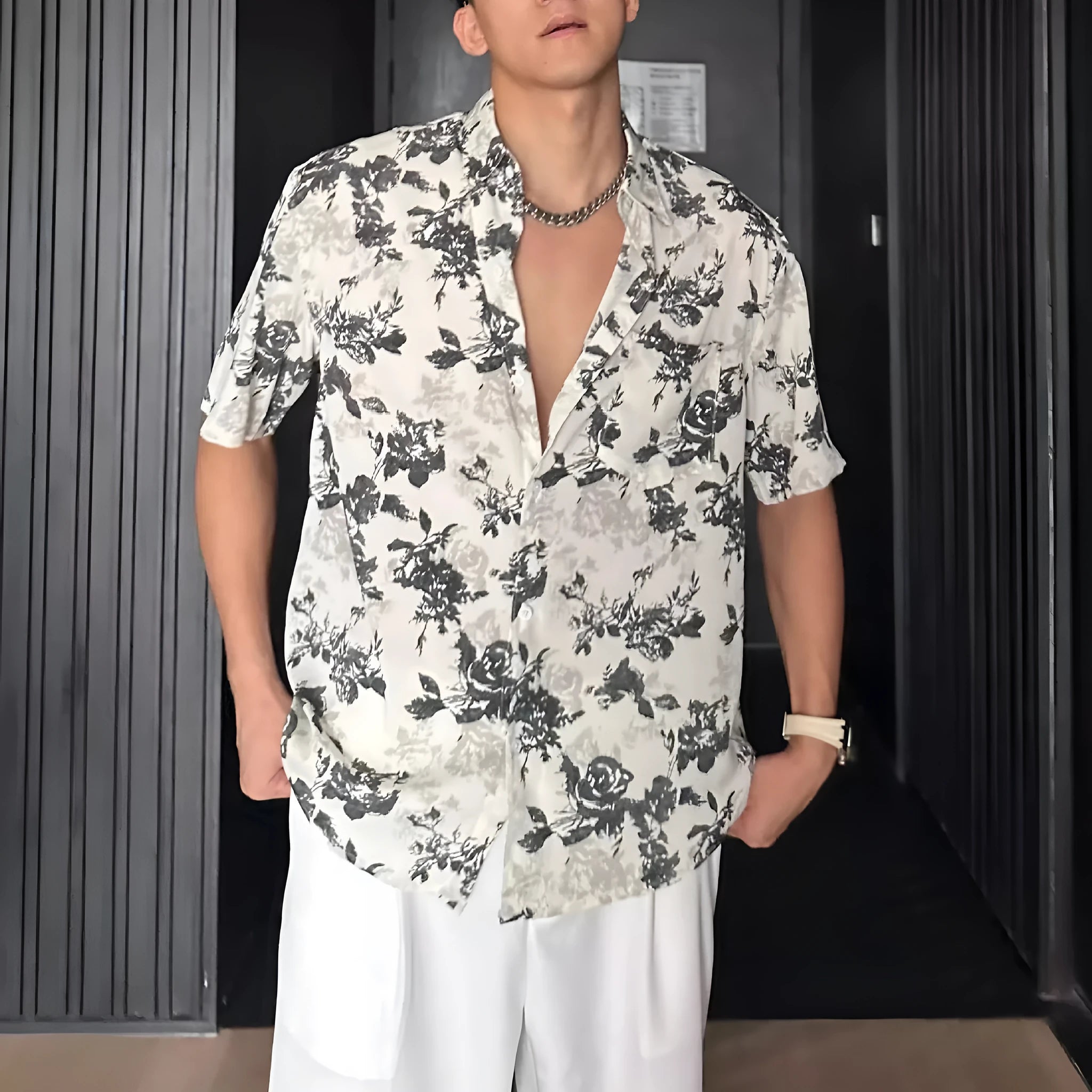 Man wearing a loose black short-sleeve shirt with a floral printed pattern.