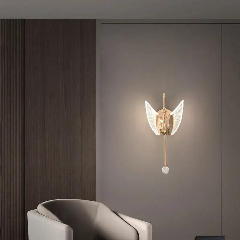 Minimalist swan-shaped wall lamp with gold finish and white acrylic shade.