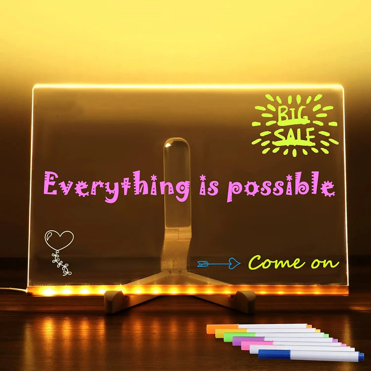Acrylic DIY LED message board night light on a desk, showing writing on the glowing transparent surface with pens nearby.