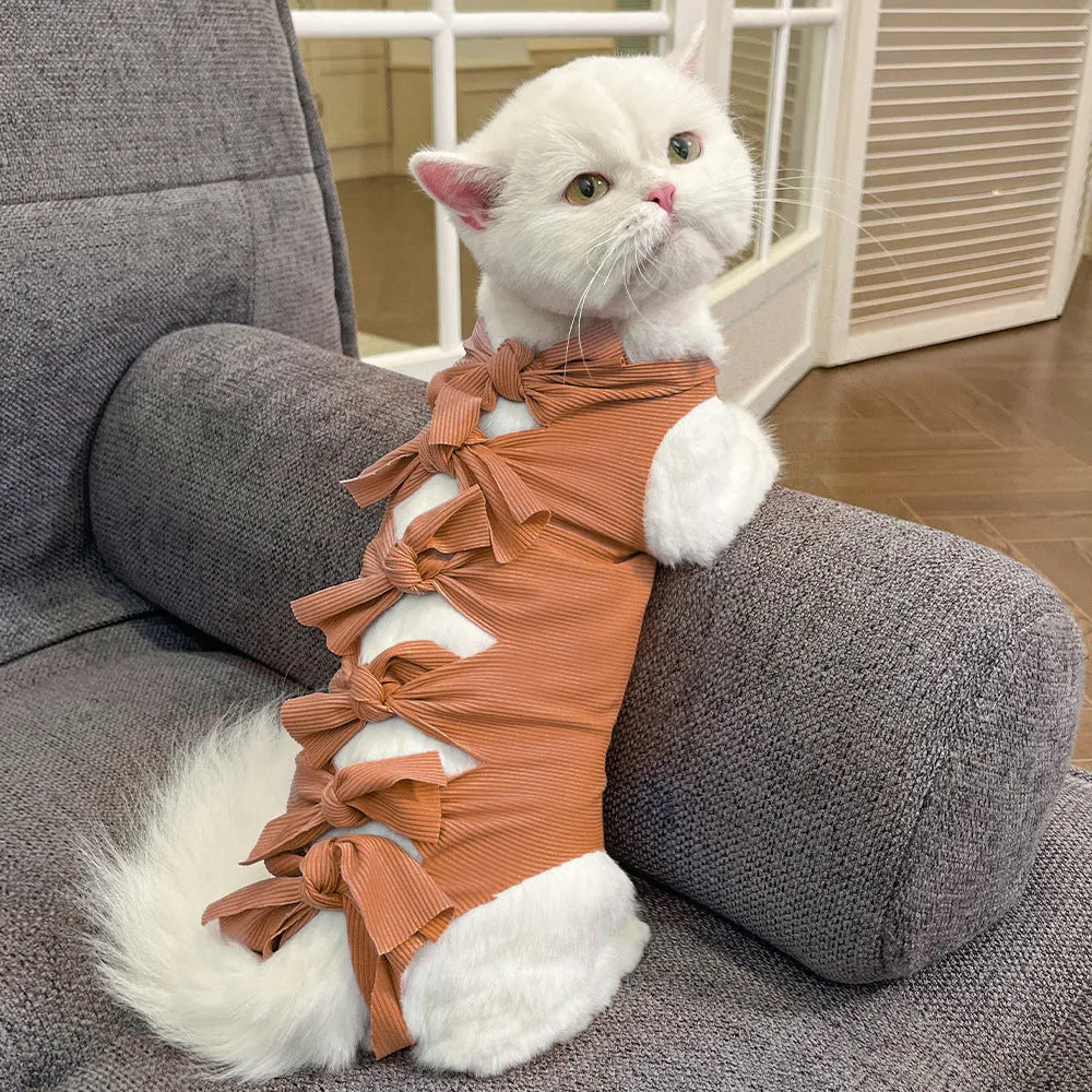Lace-up cat sterilisation clothing in pink on a cat, showing the adjustable ties and full-body coverage.