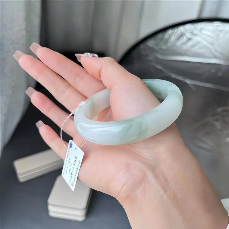 Tian Shan Cui jade bracelet with ice-like clarity and floating flower patterns on a wrist.