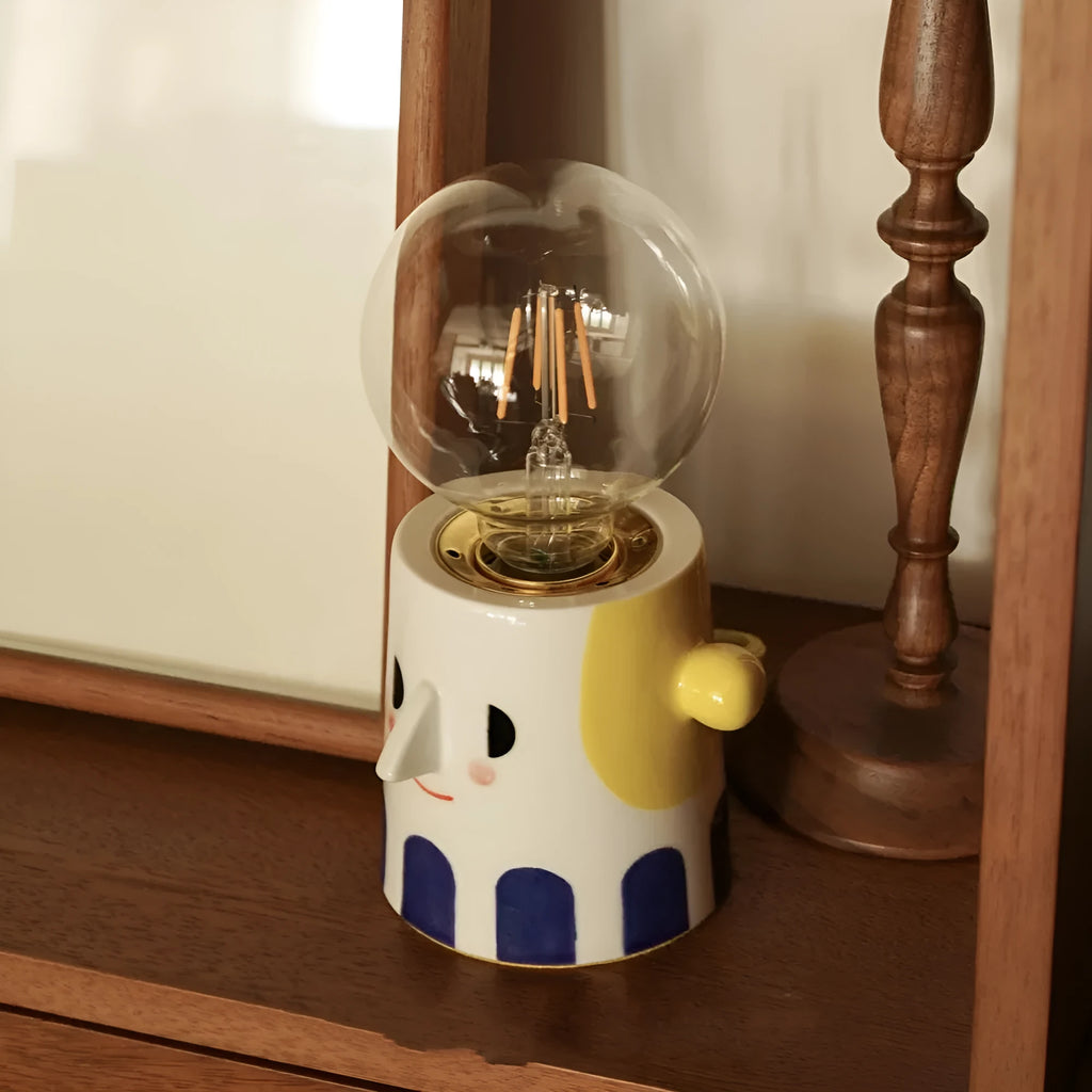 Handmade ceramic bedside lamp with a ball headlight colour finish on a table.