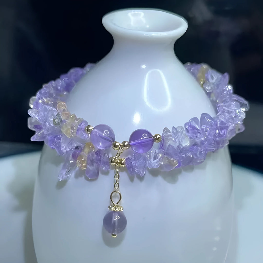 Close-up of a women's double row bracelet made from natural purple and golden D178 ametrine crystals on a wrist.