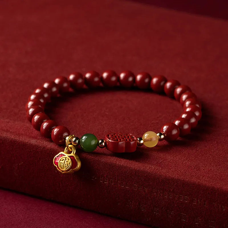 Close-up of a cinnabar Happy Eyebrow bracelet with Emperor Sandstone beads and a carved Fu character.