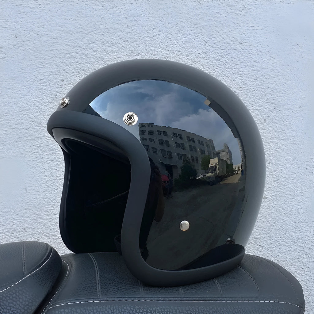 Retro-style open face motorcycle helmet in fibreglass, shown in a selection of colours including cement grey and matte black.