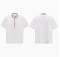 Women's loose black shirt with sequined square neckline and short sleeves on a hanger.