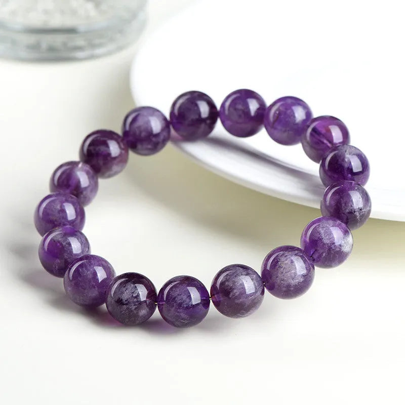 Natural purple feather amethyst crystal bracelet with geometric Ruyi design and scattered beads.