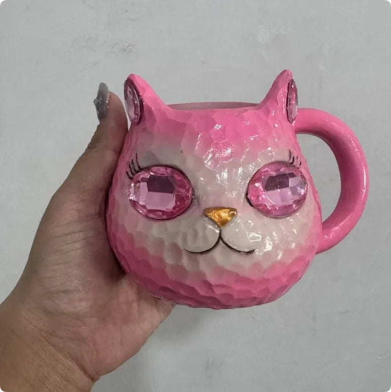 American-style resin ornament of a cat holding a crystal Earth globe in blue, green, pink, or purple.