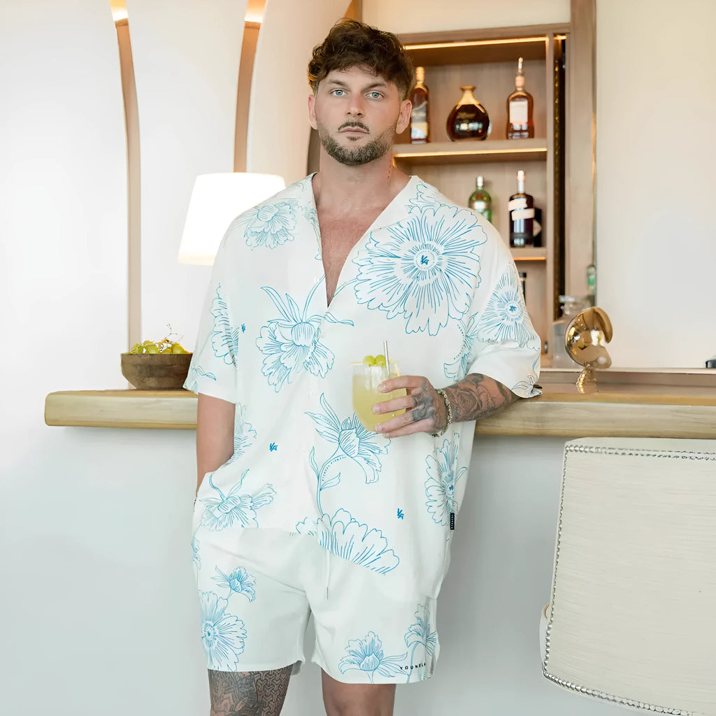 Man wearing a loose, short-sleeve floral print casual top in a cardigan style.