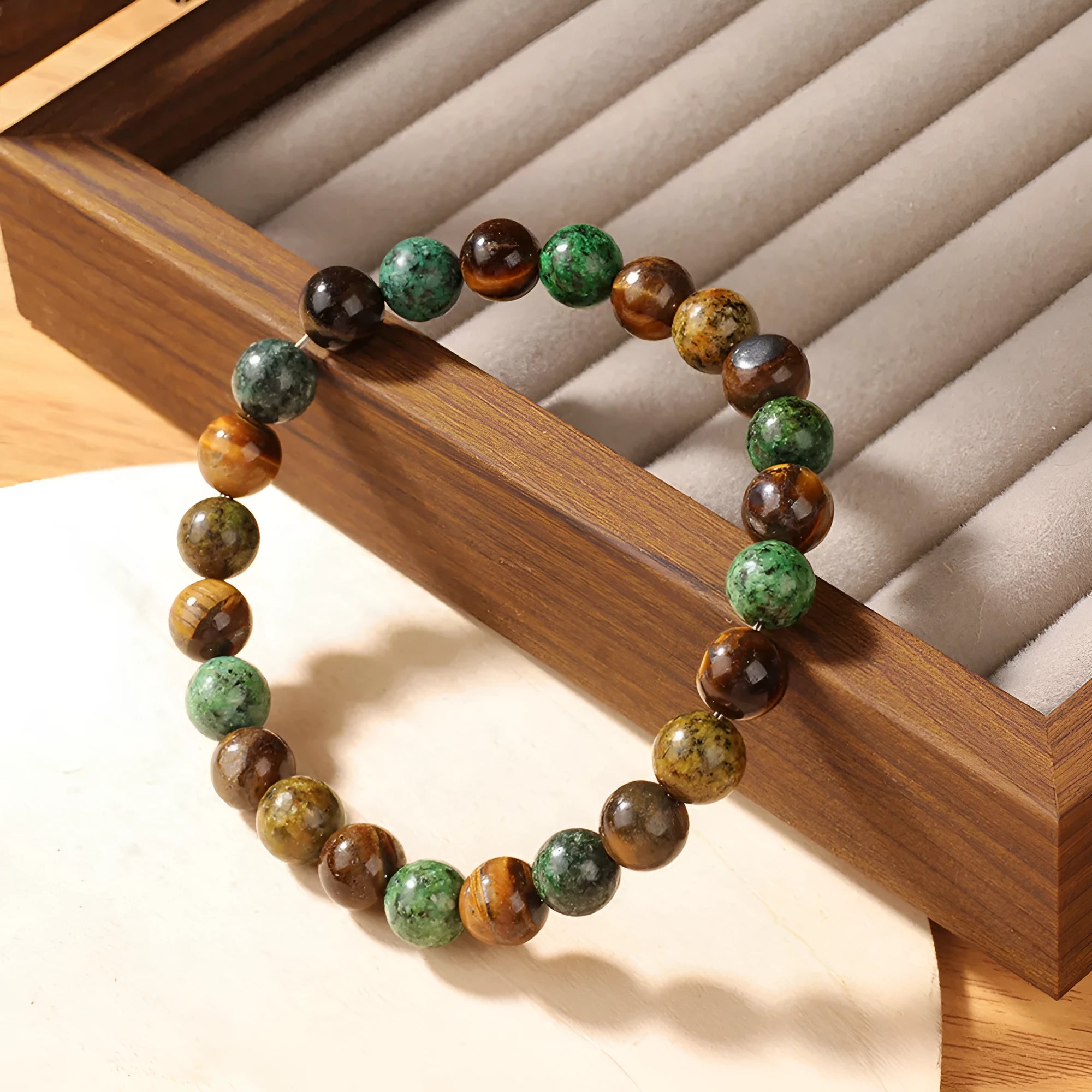 Handmade Tigereye stone bracelet with large flower-shaped bead and adjustable metal clasp on a cord.