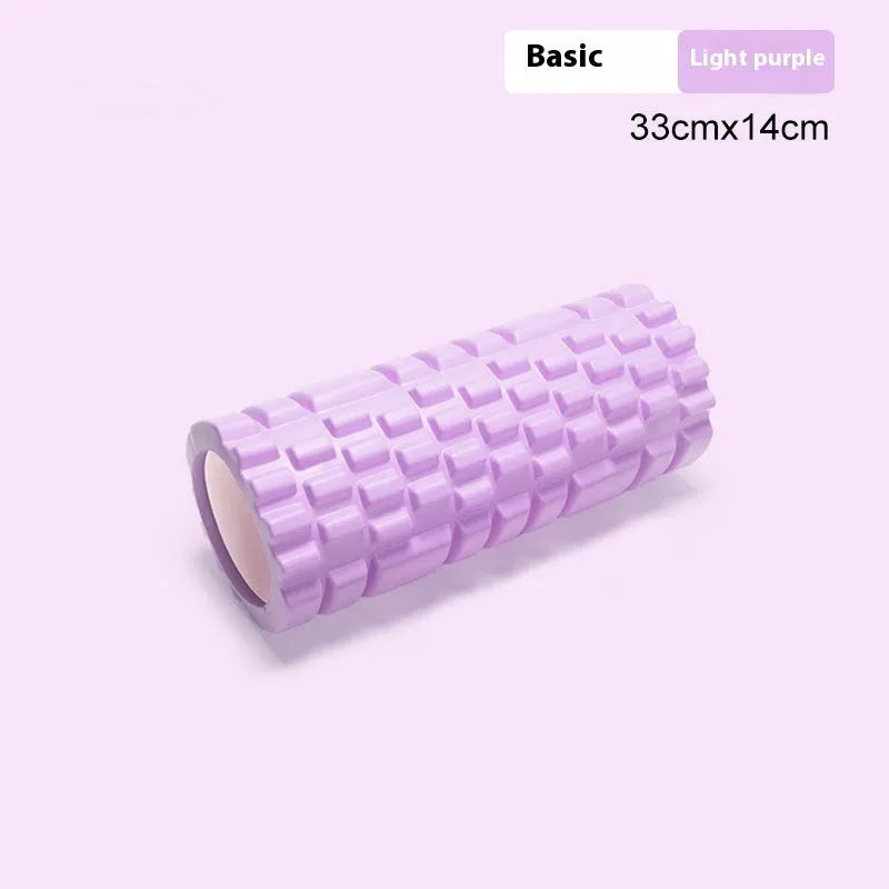 A black EVA foam roller on a gym floor, showing its cylindrical shape and texture.