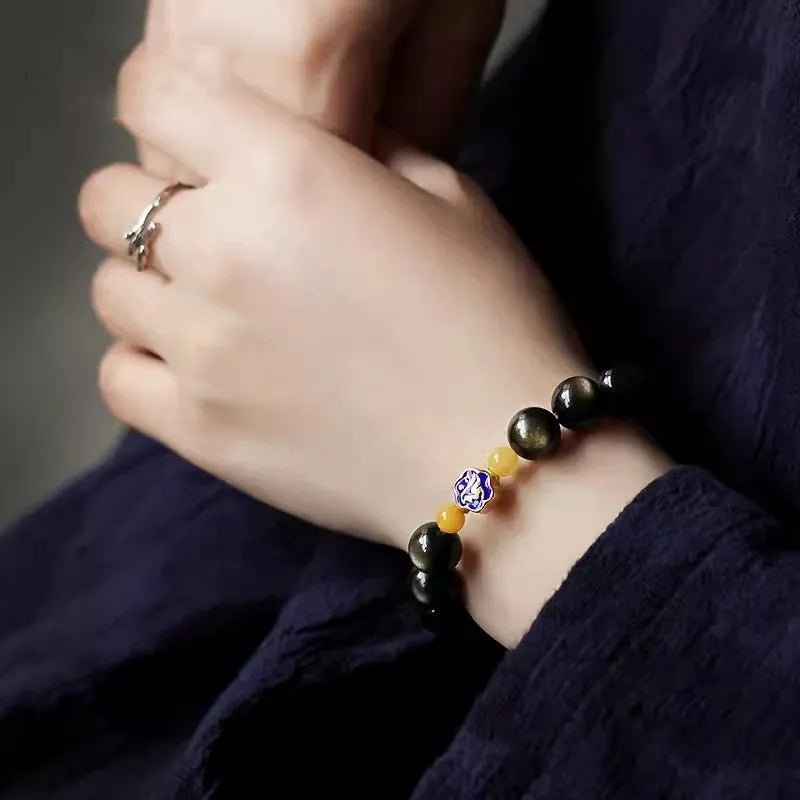 Golden obsidian bracelet with 10mm geometric zodiac beads on adjustable cord