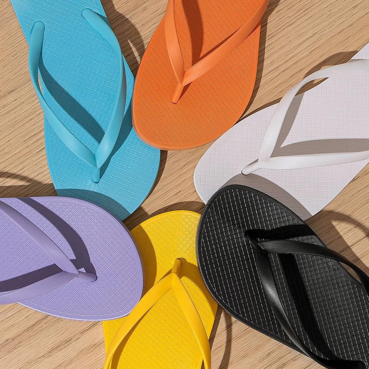 Foldable orange beach slippers with hollow out design and non-slip PVC sole.