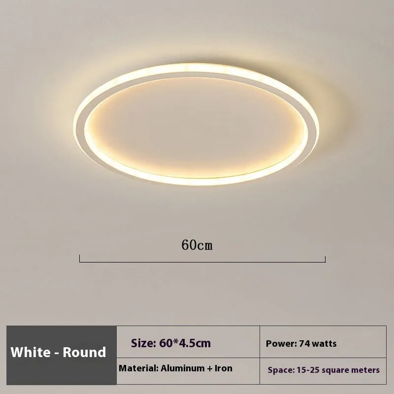 Minimalist round LED ceiling lamp in black finish with dimmable tricolour light, shown in a bedroom setting.