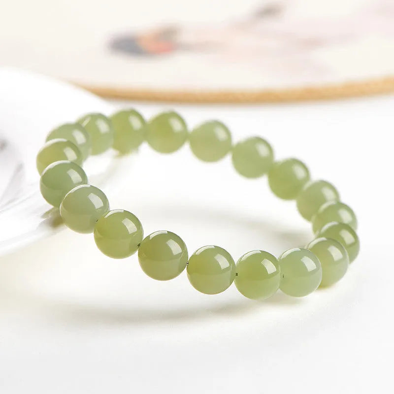 Unisex Hetian jade ball bead bracelet in ice clear colours, showing polished spherical beads on a string.