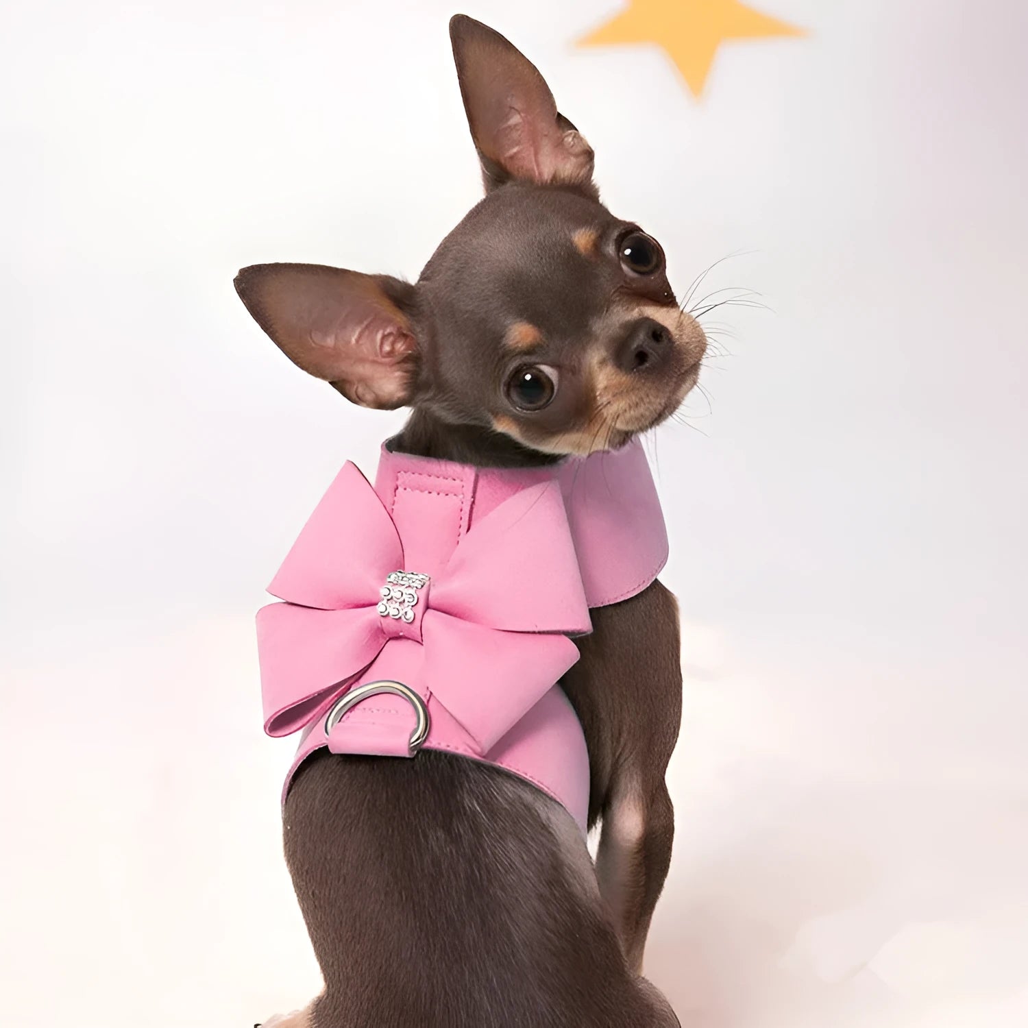 Close-up of a pink microfiber dog chest strap with a white bowknot and an adjustable metal buckle.