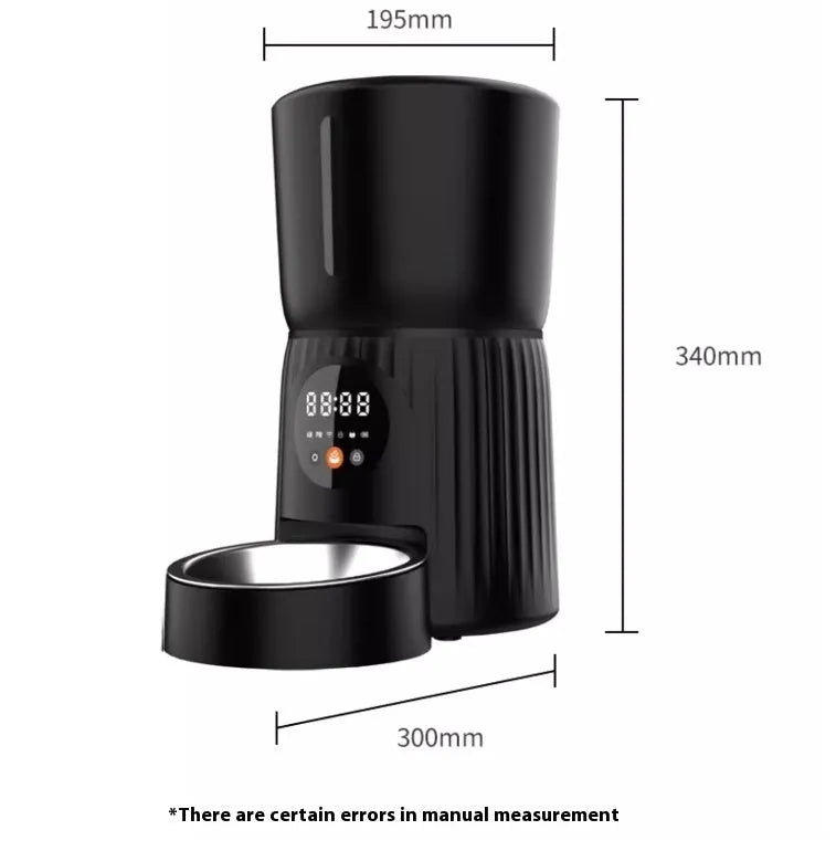 Black automatic pet feeder with digital display and stainless steel bowl on a kitchen floor.