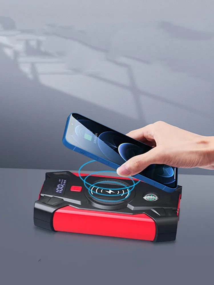 Red car emergency jump starter power pack with connection clips on a black background