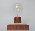 Magnetic levitation floating LED light bulb above an imitation wood base.