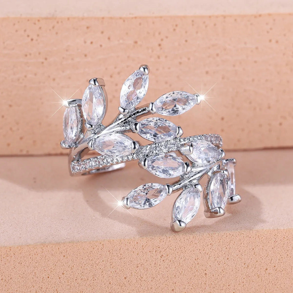 Adjustable copper ring with a detailed leaf design and zircon accents in various colour options.