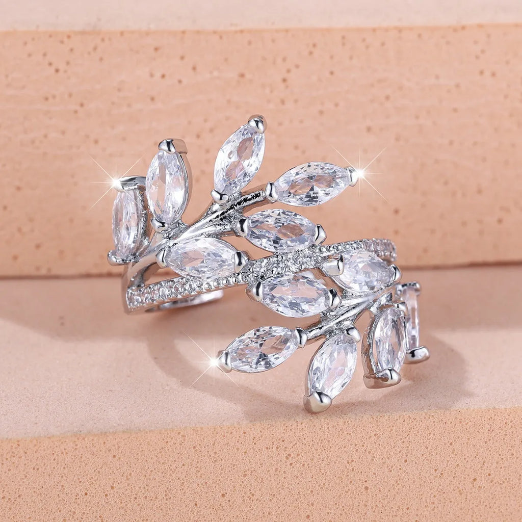 Adjustable copper leaf design ring with sparkling zircon stones on a model's finger.