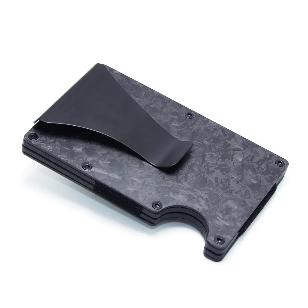 Geometric carbon fibre and aluminium business card holder, 8mm thick, on a table.