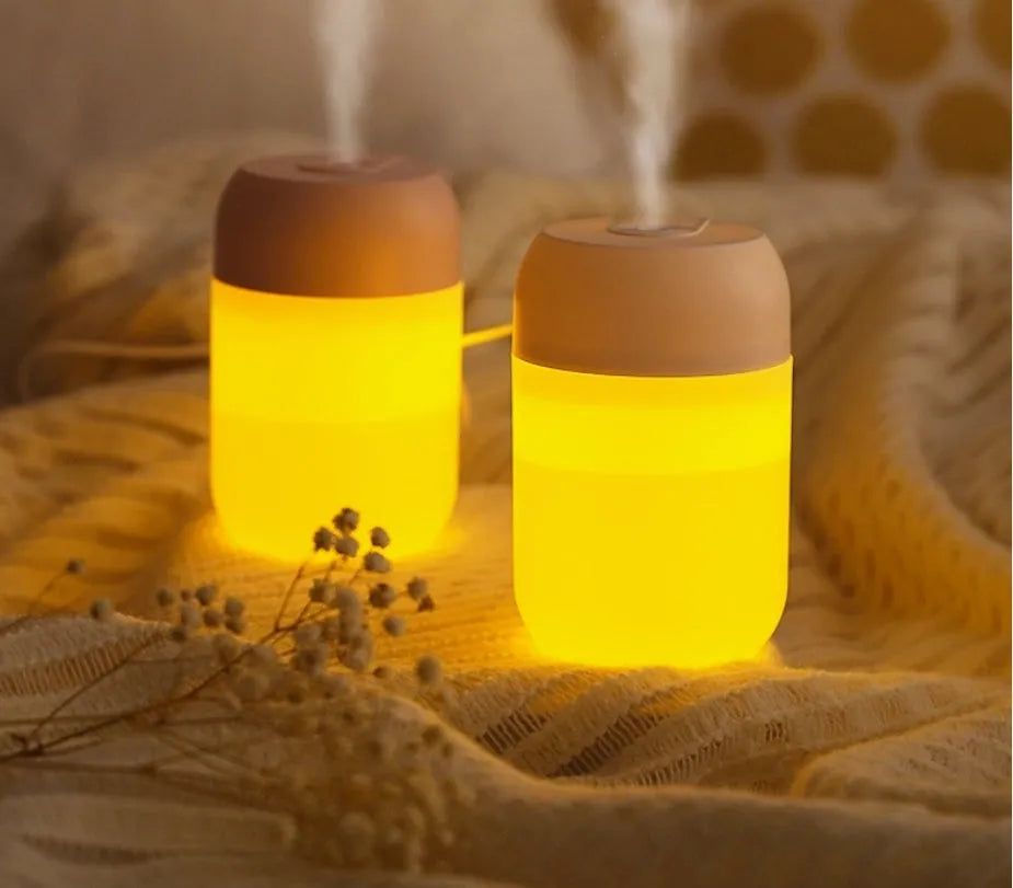 Small white cylindrical USB humidifier with charging cable for bedroom or desk use