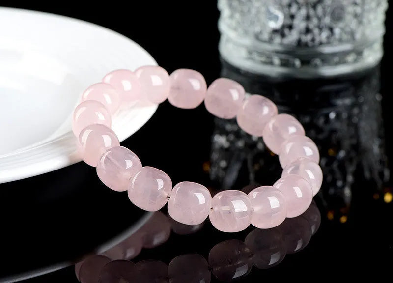 Natural pink crystal barrel bead bracelet with 11-12mm geometric design on wrist