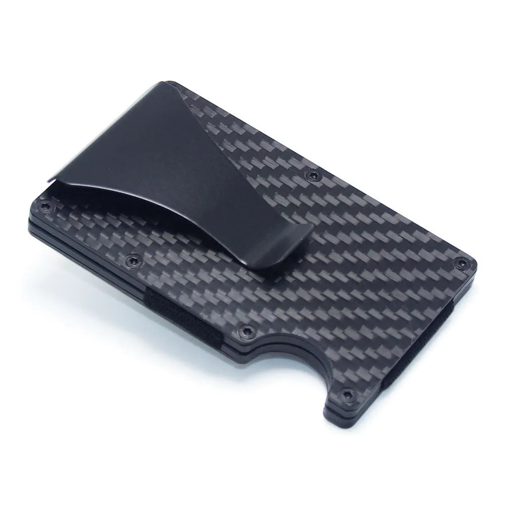 Geometric carbon fibre and aluminium business card holder, 8mm thick, on a table.