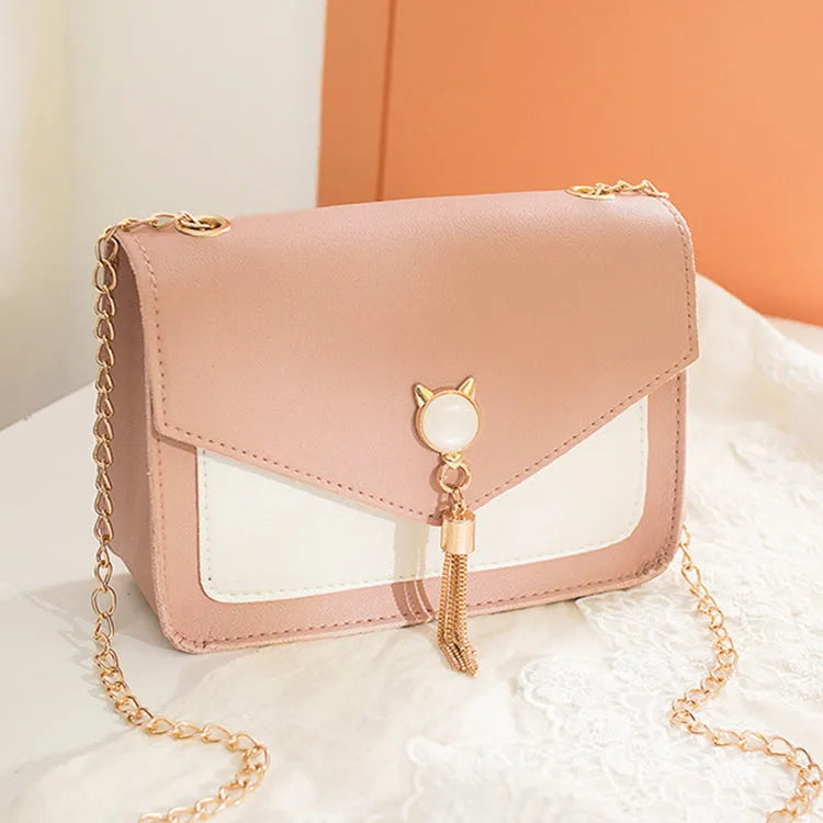 Small square PU leather crossbody bag with cat tassel decoration, magnetic flap, and adjustable chain strap in black