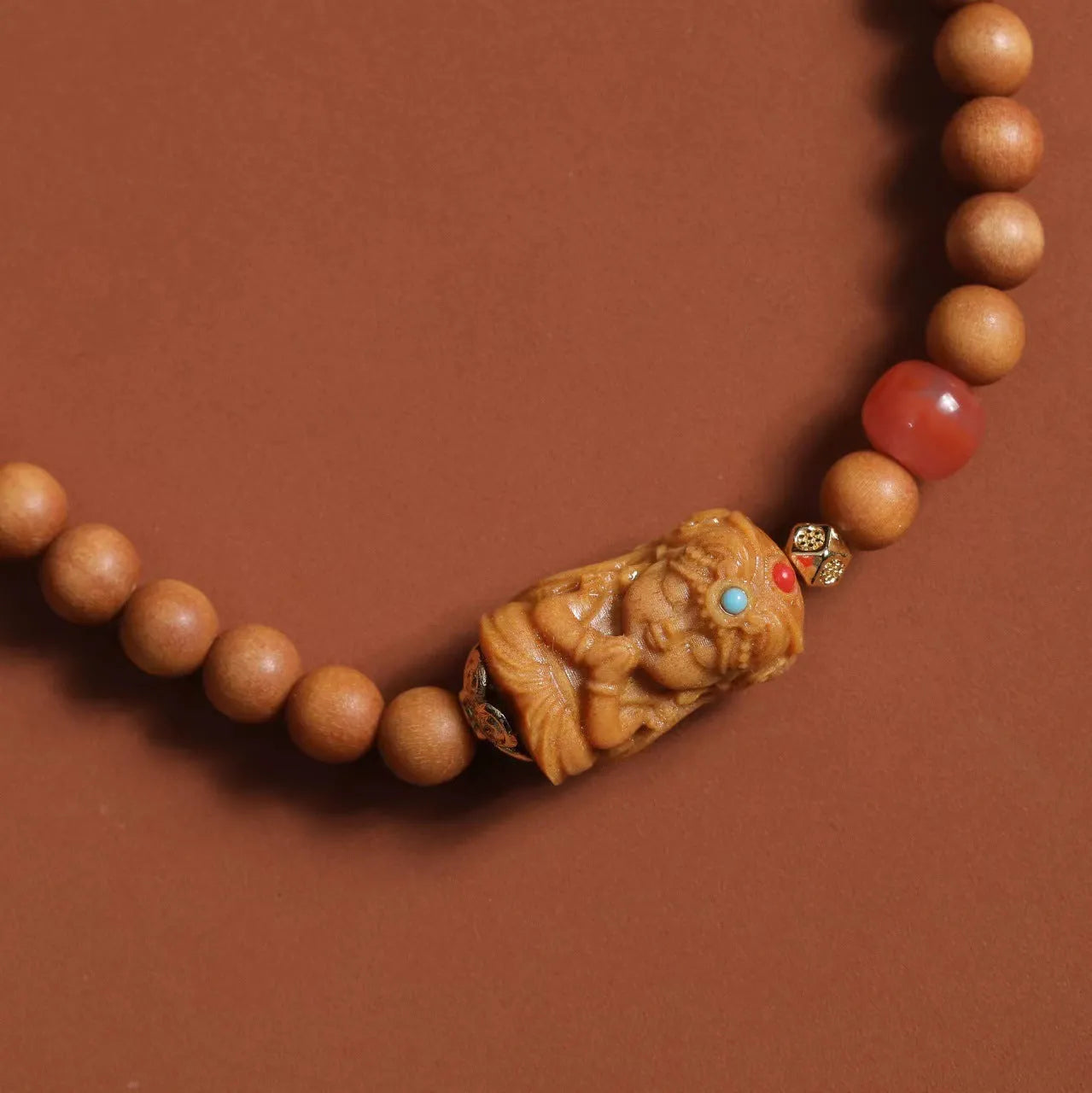 Brown sandalwood bracelet with woven South Red Zachilam design and 6mm round beads