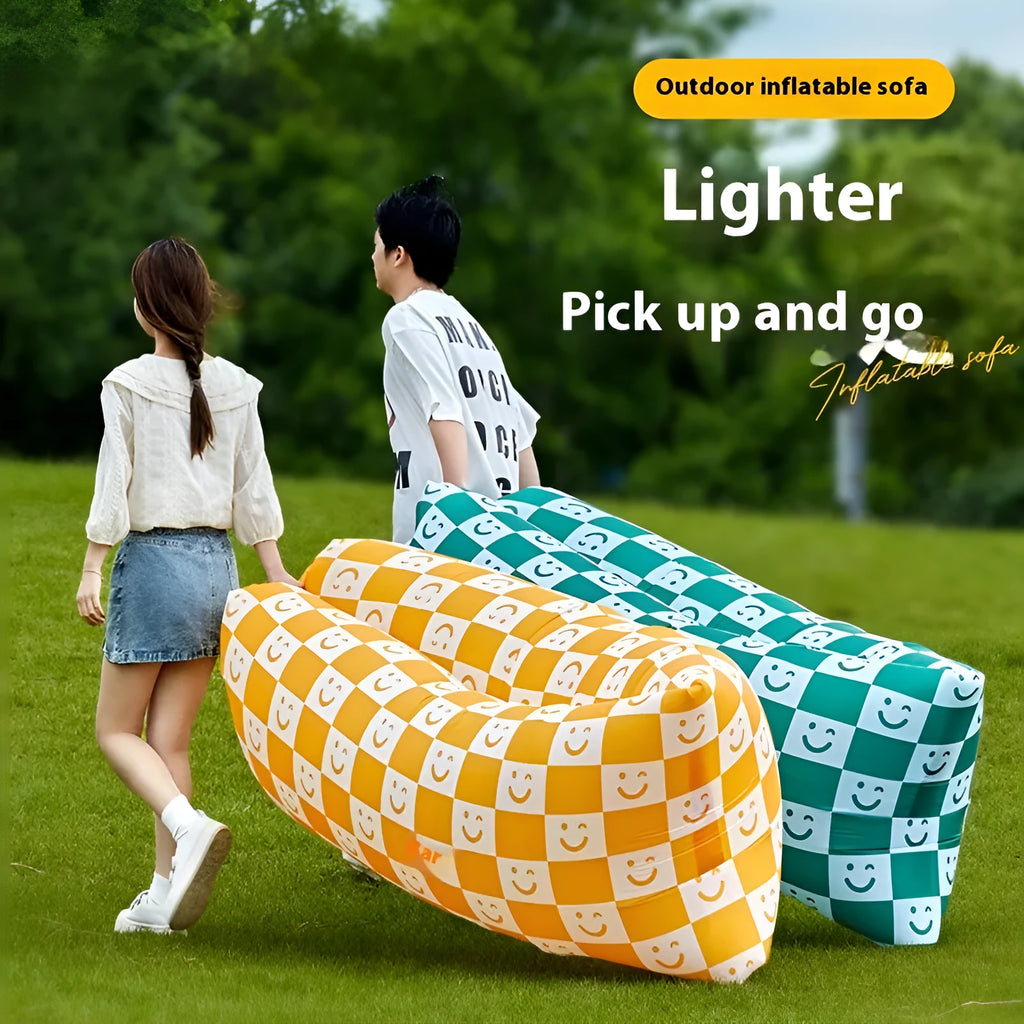 Yellow smiling face tip inflatable sofa inflated on green grass for camping