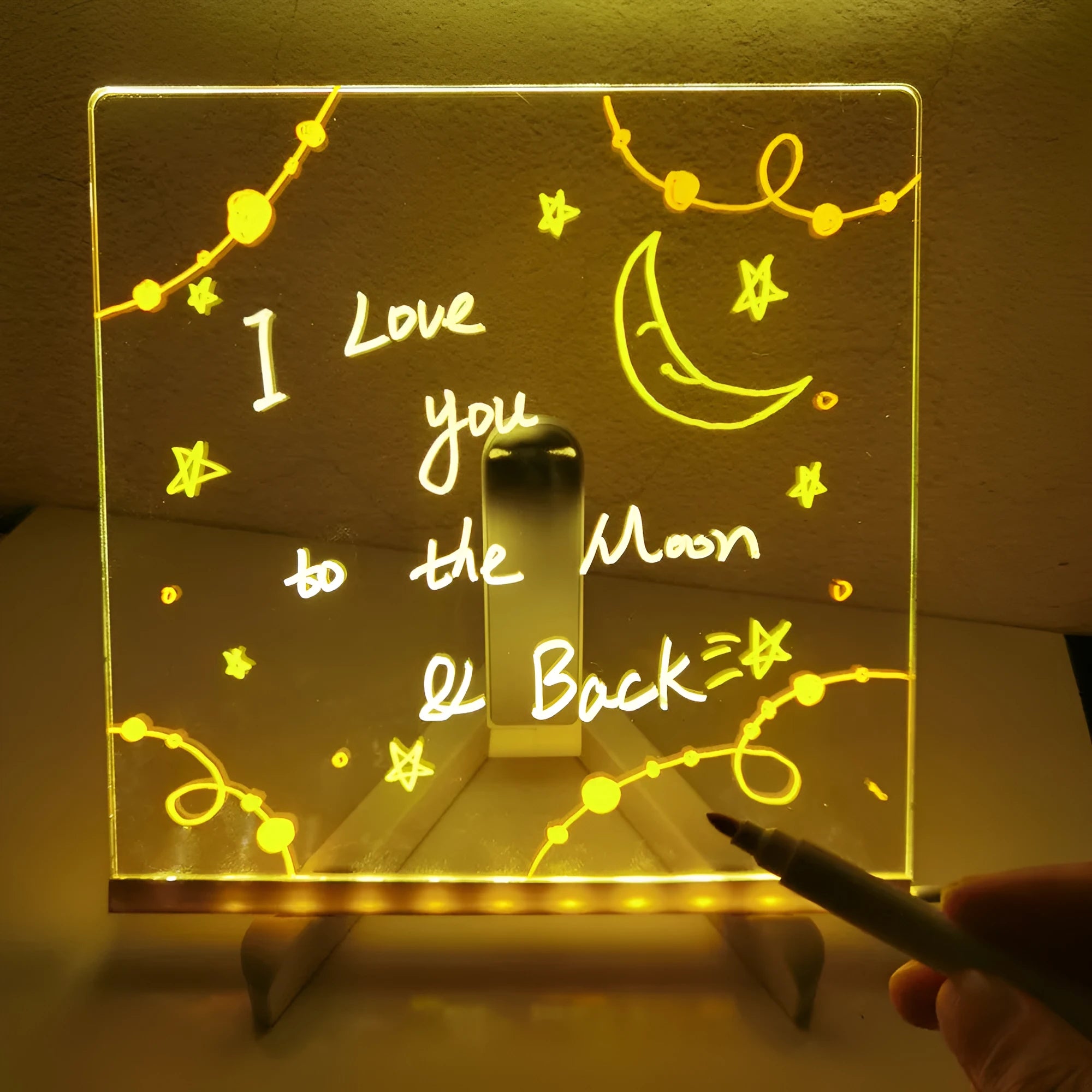 Acrylic DIY LED message board night light on a desk, showing writing on the glowing transparent surface with pens nearby.