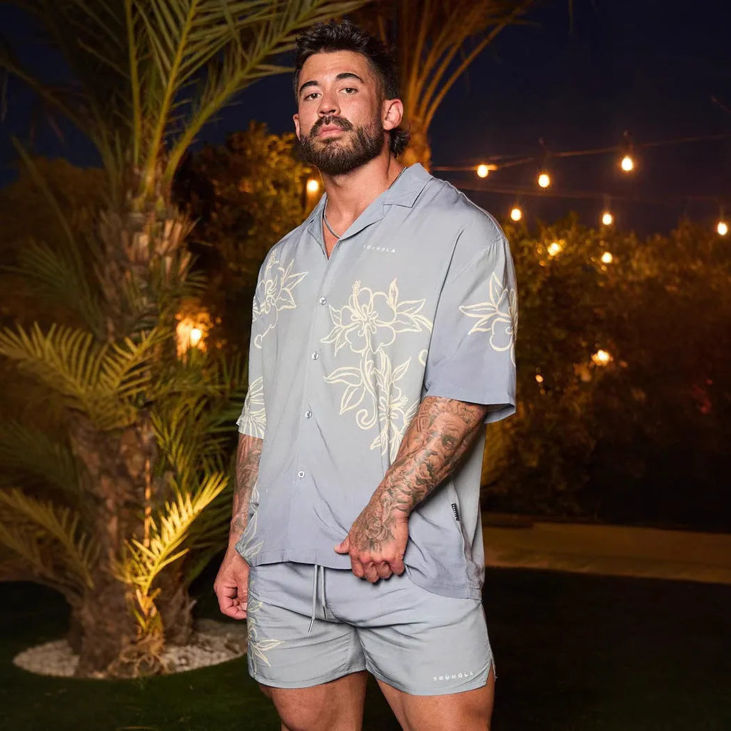Man wearing a loose, short-sleeve floral print casual top in a cardigan style.
